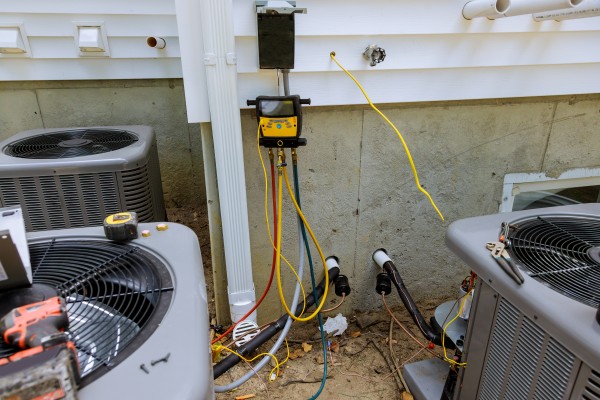 Technician repairing the air conditioner outdoors with multimeter meter liquid cooling