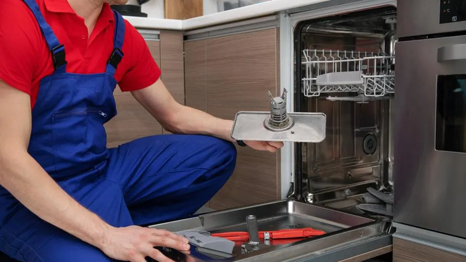 Man repairing a dishwasher.